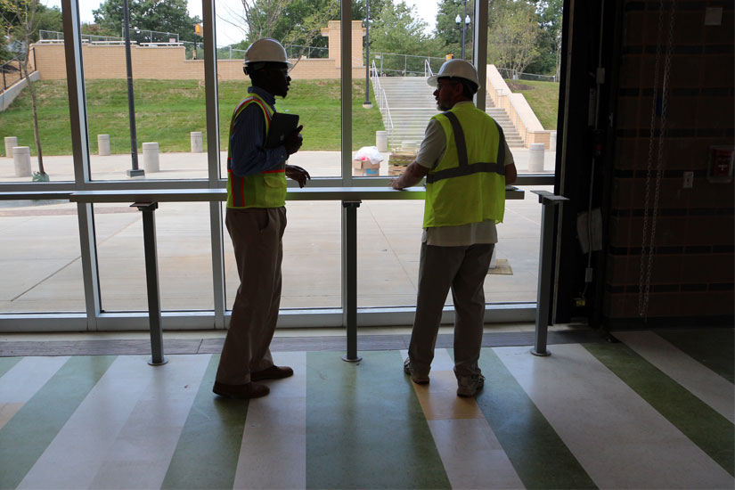 Two construction workers look out onto Wakefield's plaza and pedestrian entrance