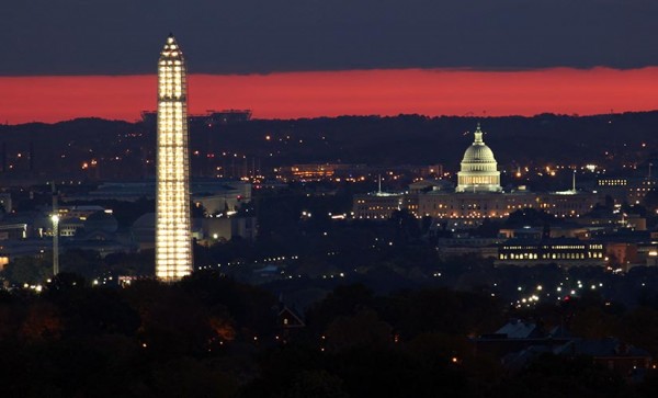 The Capitol and the Washington monument at sunrise, as seen from the top of a Ballston apartment building. FedEx Field and a Six Flags roller coaster are visible in the background. (Photo courtesy Andrew Clegg)