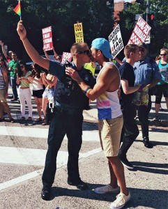 Arlington County police officer kisses his boyfriend at the 2014 Capital Pride Parade (photo via Twitter)