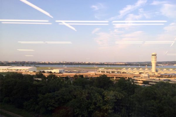 Fluorescent office lights can be seen as reflections in a window overlooking Reagan National Airport