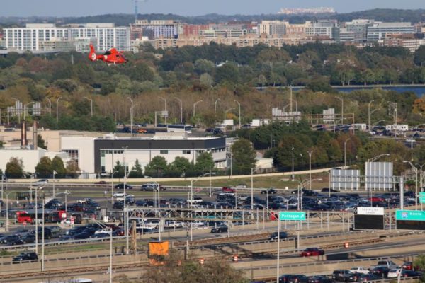 Coast Guard helicopter flies near I-395 and the Pentagon, with FedEx Field visible in the distance