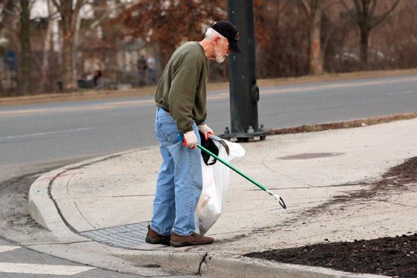 Man cleaning up trash on Four Mile Run Drive