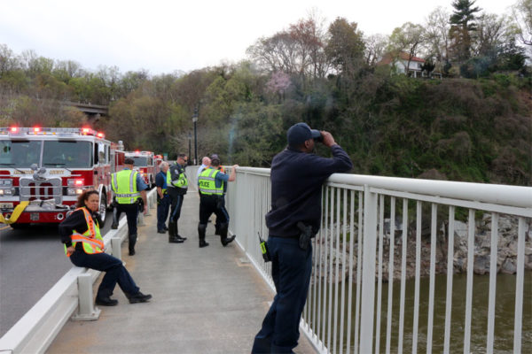 Emergency workers watch Arlington's technical rescue team rappel to the dead body