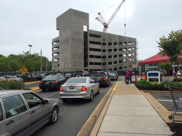 Under-construction parking garage rises above the busy Costco parking lot