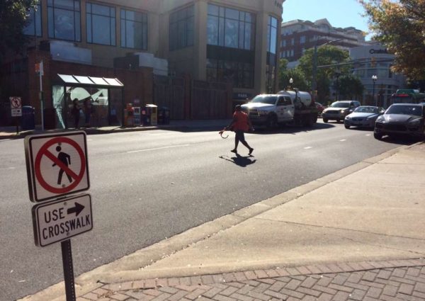 Pedestrian crossing the street in Clarendon in front of traffic