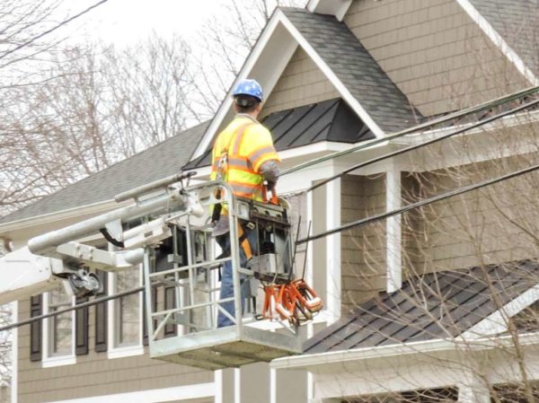 A lineman working on power lines (Flickr pool photo by Alan Kotok)